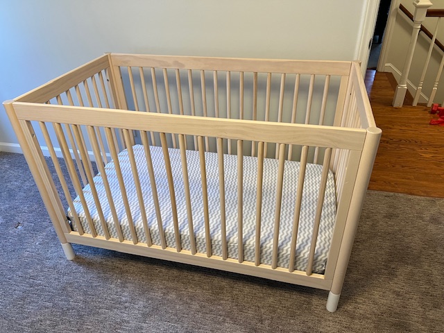 A quiet, empty crib reflecting the grief and acceptance of letting go of parenthood dreams